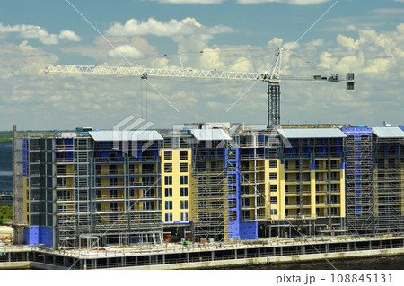 Tower lifting cranes at high residential apartment buildings construction site. Real estate development Tower lifting cranes at high residential apartment buildings construction site. Real estate development 108845131