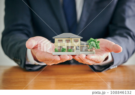住宅模型を手のひらに置く男性弁護士 108846132