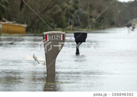 Hurricane flooded street with mail box surrounded with water in Florida residential area. Consequences of natural disaster Hurricane flooded street with mail box surrounded with water in Florida residential area. Consequences of natural disaster 108846302