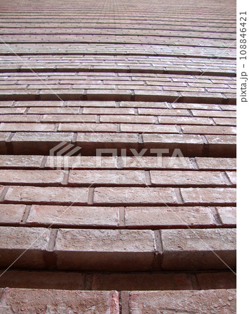 Red Brick Wall with grooves going upward 108846421