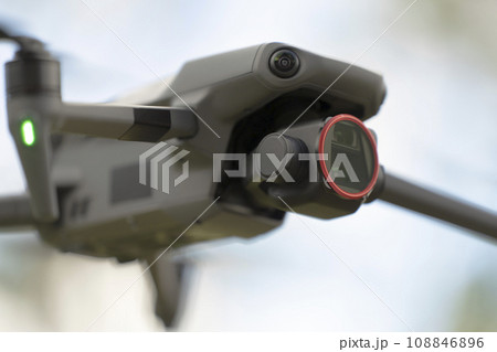 Drone aircraft with blurred fast rotating propellers and video camera flying in air 108846896