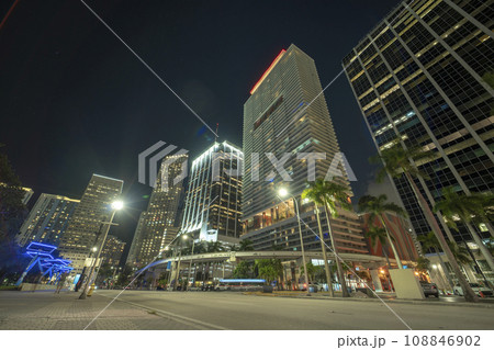Downtown of Miami Brickell in Florida, USA. Brightly illuminated high skyscraper buildings and street with car trails and metrorail traffic in modern american midtown 108846902