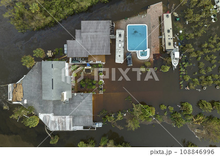 Consequences of natural disaster. Heavy flood with high water surrounding residential houses after hurricane Ian rainfall in Florida residential area 108846996