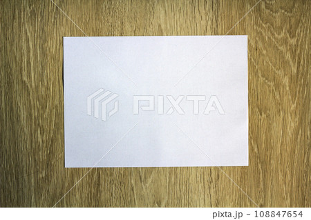 Blank white piece of paper on wooden background Blank white piece of paper on wooden background 108847654