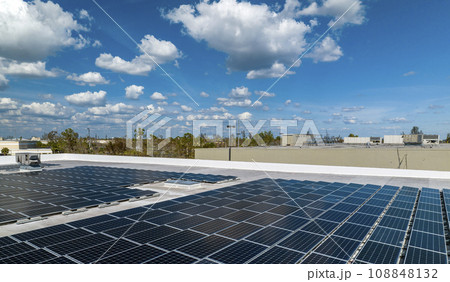 Aerial view of solar power plant with blue photovoltaic panels mounted on industrial building roof for producing green ecological electricity. Production of sustainable energy concept 108848132