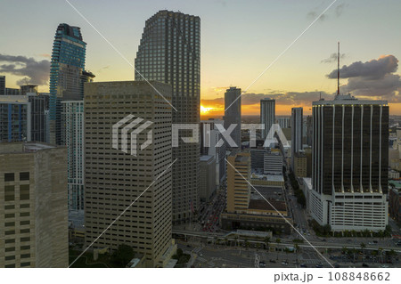 Aerial view of downtown district of of Miami Brickell in Florida, USA at sunset. High skyscraper buildings and street with cars and Metrorail traffic in modern american midtown 108848662