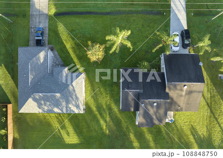 Aerial landscape view of suburban private houses between green palm trees in Florida quiet rural area 108848750
