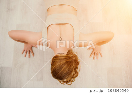 Young sporty woman, fitness instructor in sportswear doing stretching and pilates on yoga mat in the studio with mirror. Female fitness yoga routine concept. Healthy lifestyle and harmony. 108849540