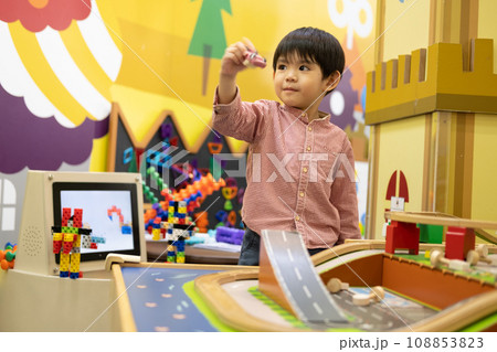 Little Asian boy playing with toy car in the children's play park Little Asian boy playing with toy car in the children's play park 108853823