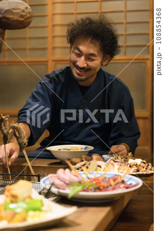 旅館での宿泊でご飯を楽しむ男性 旅館での宿泊でご飯を楽しむ男性 108854368