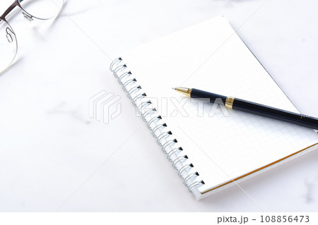リング式のメモ帳とペンでデスクワーク 108856473
