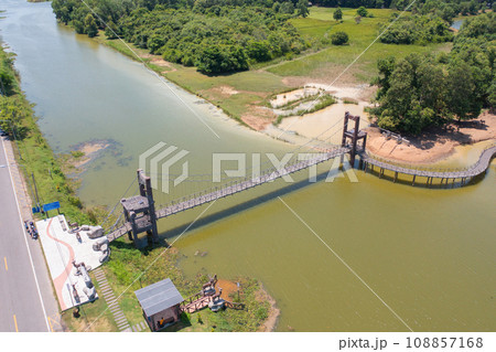 Aerial top view of a bridge with garden park with green mangrove forest trees, river, pond or lake. Nature landscape background, Thailand. 108857168