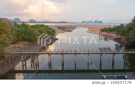 Aerial top view of a bridge with garden park with green mangrove forest trees, river, pond or lake. Nature landscape background, Thailand. 108857176
