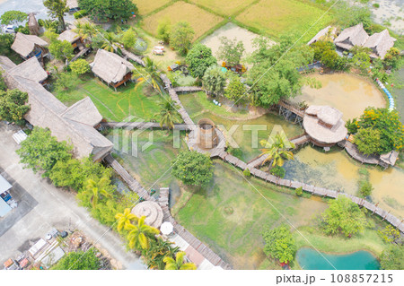 Aerial top view of a bridge with garden park with green mangrove forest trees, river, pond or lake. Nature landscape background, Thailand. 108857215