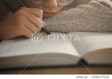 Boring student girl lying on book and reading book, Student girl at boring lesson feeling tired or depressed. 108857616