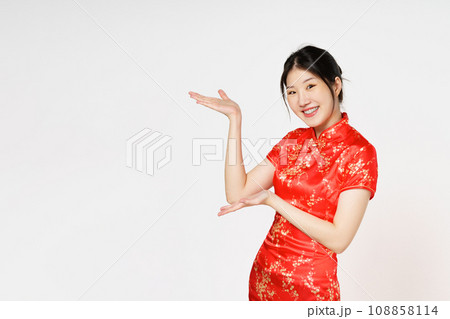 Happy Chinese new year. Asian woman wearing traditional cheongsam qipao dress with gesture of introduce isolated on white background. Happy Chinese new year. Asian woman wearing traditional cheongsam qipao dress with gesture of introduce isolated on white background. 108858114