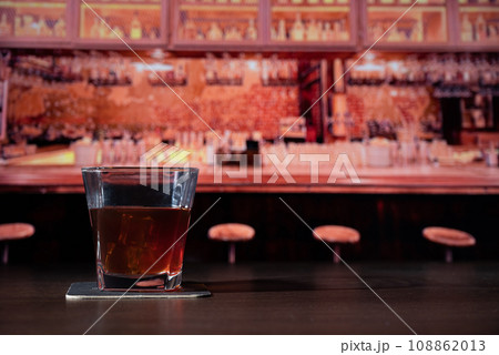 Glass of whiskey on the bar in front of the blur image bar Glass of whiskey on the bar in front of the blur image bar 108862013