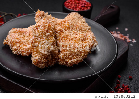 Delicious fresh crispy chicken nuggets on a dark concrete background Delicious fresh crispy chicken nuggets on a dark concrete background 108863212