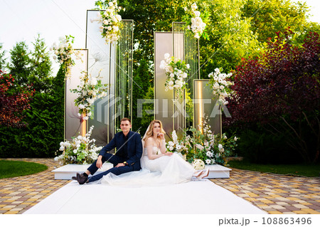 The bride and groom sit on the podium for off-site registration.  108863496