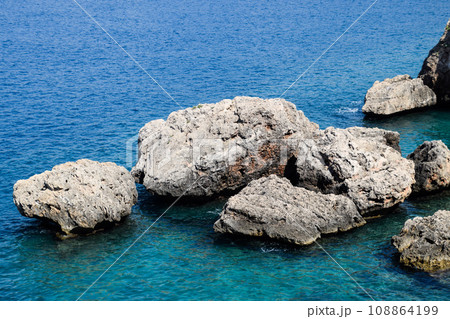 Limestone cliffs by sea. Waves beat on the rocks. 108864199