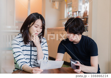 請求書明細を見て値上げに苦しむ若い夫婦 108866214