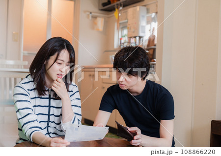 請求書明細を見て値上げに苦しむ若い夫婦 108866220