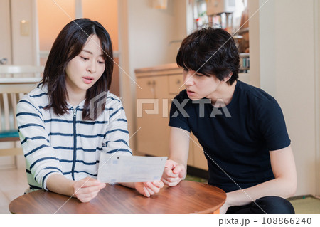 請求書明細を見て値上げに苦しむ若い夫婦 請求書明細を見て値上げに苦しむ若い夫婦 108866240