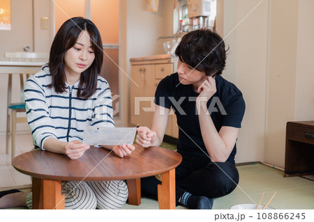 請求書明細を見て値上げに苦しむ若い夫婦 108866245