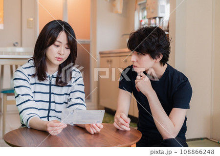請求書明細を見て値上げに苦しむ若い夫婦 108866248