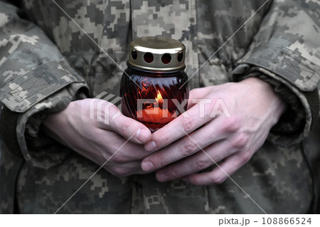 Ukrainian seviceman holds a candle. Candle in hands of Soldier Ukrainian seviceman holds a candle. Candle in hands of Soldier 108866524