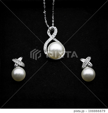 Close up macro photography Pearl and Diamond earring and necklace jewelry set on black velvet background. Close up macro photography Pearl and Diamond earring and necklace jewelry set on black velvet background. 108866879