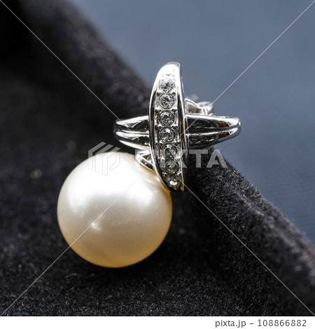 Close up macro photography Pearl and Diamond earring and necklace jewelry set on black velvet background. 108866882