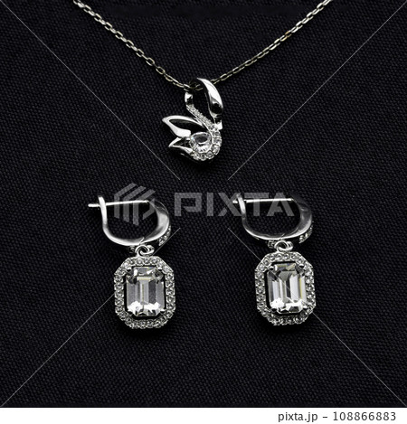 Close up macro photography, swan and octagon diamond earring and necklace jewelry set of cloth black background. Close up macro photography, swan and octagon diamond earring and necklace jewelry set of cloth black background. 108866883