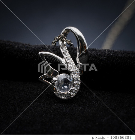 Close up macro photography, swan and octagon diamond earring and necklace jewelry set of cloth black background. Close up macro photography, swan and octagon diamond earring and necklace jewelry set of cloth black background. 108866885