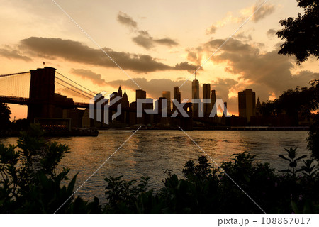 New York cityscape at sunset. New York City, financial district in lower Manhattan view from Brooklyn Bridge Park. New York cityscape at sunset. New York City, financial district in lower Manhattan view from Brooklyn Bridge Park. 108867017
