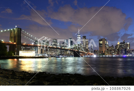 New York City, financial district in lower Manhattan with Brooklin Bridge at night, USA 108867026