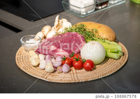 close up to Raw Ingredients for beef steak and mushroom sauce menu on circle wicker plate. close up to Raw Ingredients for beef steak and mushroom sauce menu on circle wicker plate. 108867578
