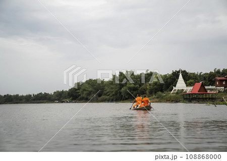 2 monks rowing along the river to receive alms in the morning. 108868000