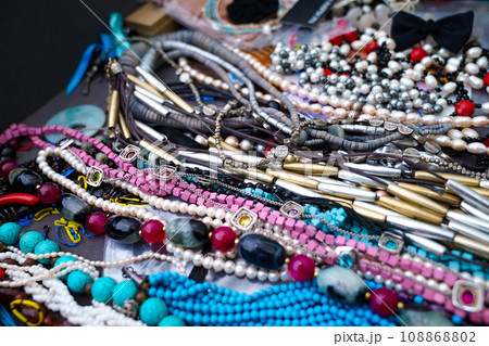 Necklaces made of beads of various colors, shapes, and materials are lining the shelves. Even though the composition is different, it creates a more positive appearance. 108868802