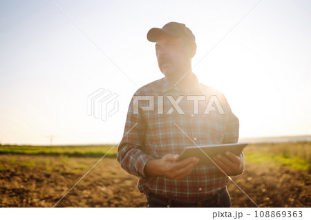 Male hands touching soil on the field. Expert hand of farmer checking soil health. Ecology concept. 108869363