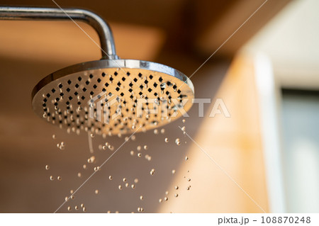 Close up to Outdoor shower head for the bath and showering cold water to body before jumping in the resort pool. Close up to Outdoor shower head for the bath and showering cold water to body before jumping in the resort pool. 108870248