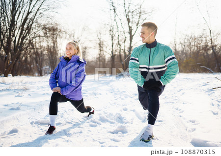 Young couple winter morning exercise at snowy forest. Healthy fitness lifestyle. Sport, Active life. Young couple winter morning exercise at snowy forest. Healthy fitness lifestyle. Sport, Active life. 108870315