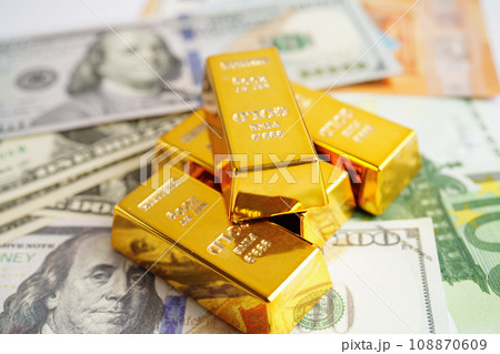 Gold bars with US dollar and Euro banknote money, finance trading investment business currency concept. Gold bars with US dollar and Euro banknote money, finance trading investment business currency concept. 108870609