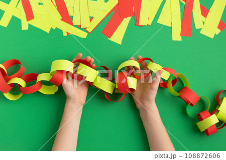 girl hands making paper chain for new year christmas decoration dyi easy occupation at home 108872606