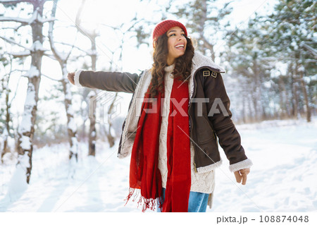 Happy woman standing among snowy trees and enjoying first snow. Holidays, rest, travel concept Happy woman standing among snowy trees and enjoying first snow. Holidays, rest, travel concept 108874048