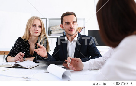 Group of people deliberate on white board 108875012