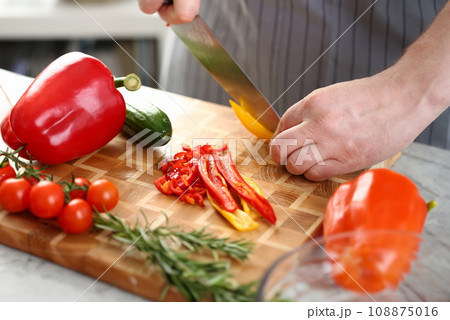 Male Hands Cutting Yellow Chili Salad Ingredient Male Hands Cutting Yellow Chili Salad Ingredient 108875016