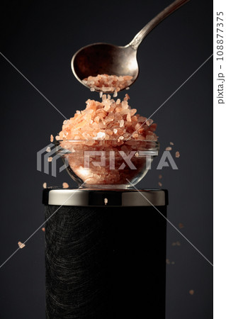 Pink salt is poured into a small bowl. Pink salt is poured into a small bowl. 108877375