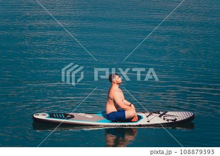 man on paddleboard in the middle of the lake 108879393