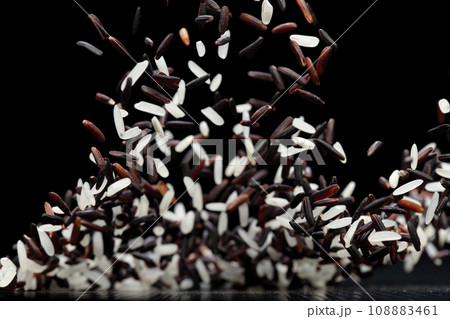 Japanese Riceberry flying explosion, white grain rices berry fall abstract fly. Beautiful complete seed jasmine riceberry splash in air, food object. Black background isolated selective focus blur 108883461